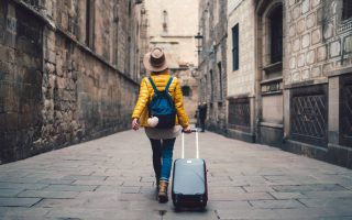 Chica con maleta en mano viajando sola
