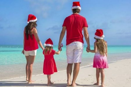 Familia con gorros navideños en la playa